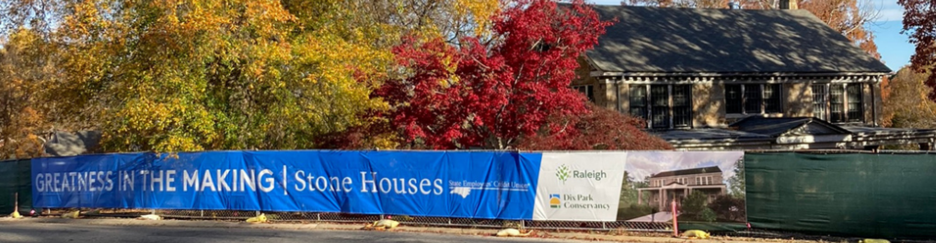 Stone Houses under construction with fence scrim banner