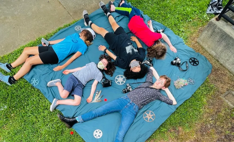 people laying on a piece of fabric