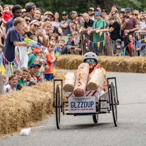 Man in hot dog cart racing downhill