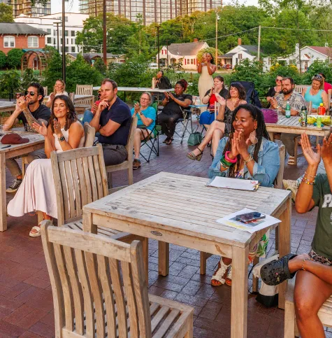 people seating at outside tables clapping