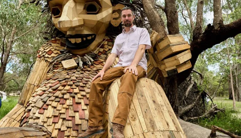 Thomas Dambo with a Troll sculpture