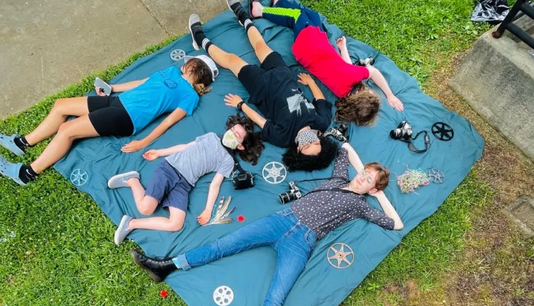 people laying on a piece of fabric