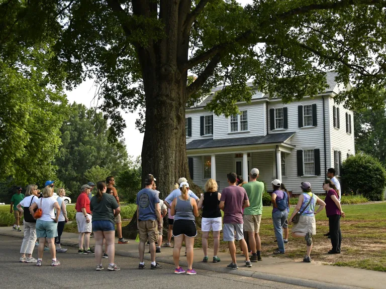 Adults on an tour in front of a house