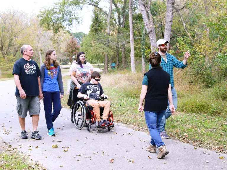 group of adults walking and one in a wheelchair